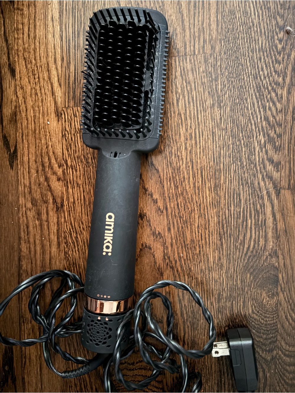 amika heated straightening brush with rose gold accents.